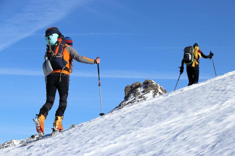 Sneeuwbedekt berglandschap met skiërs op piste in Westland